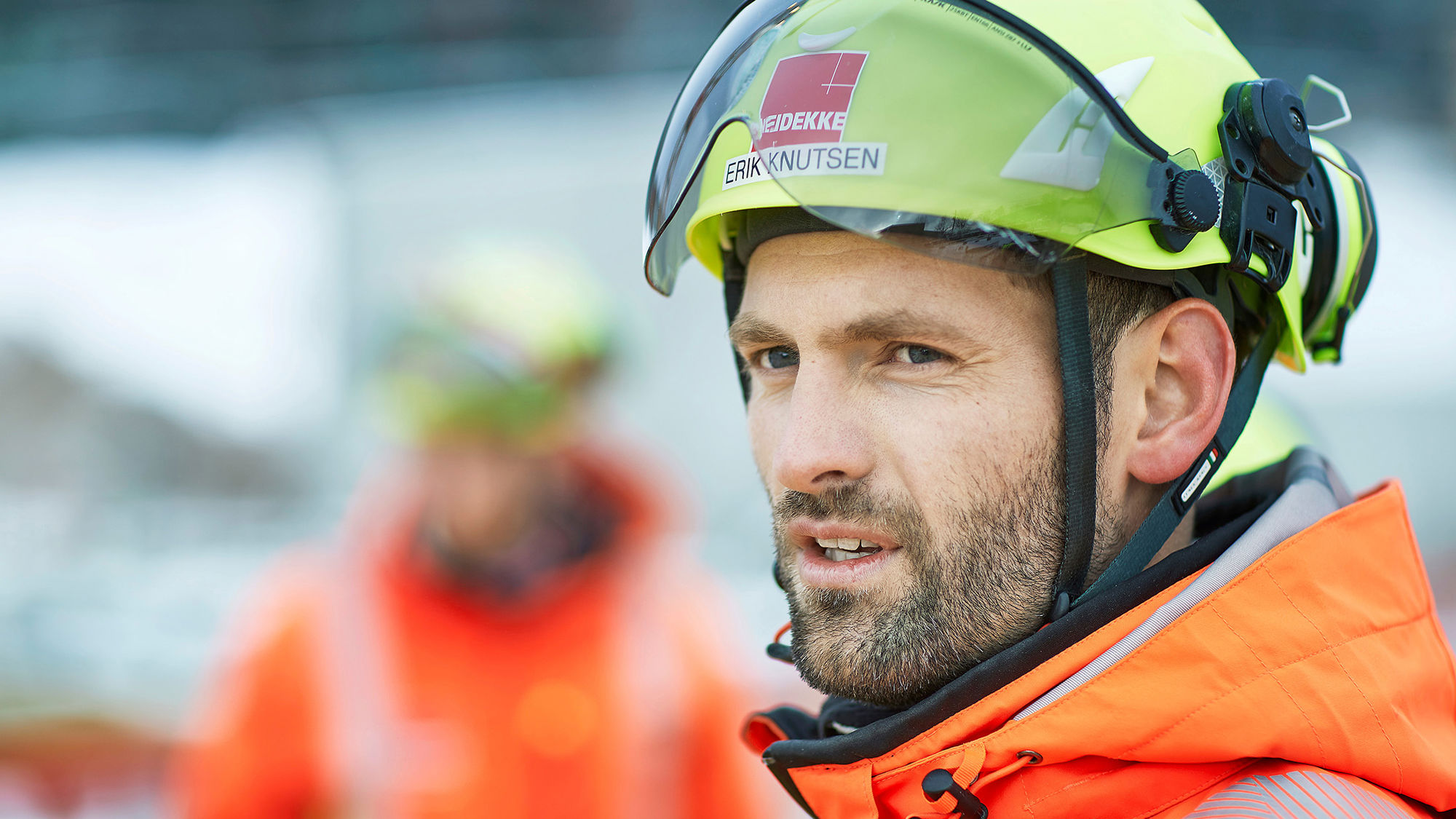 Man wearing yellow helmet looking to the left. Photo.