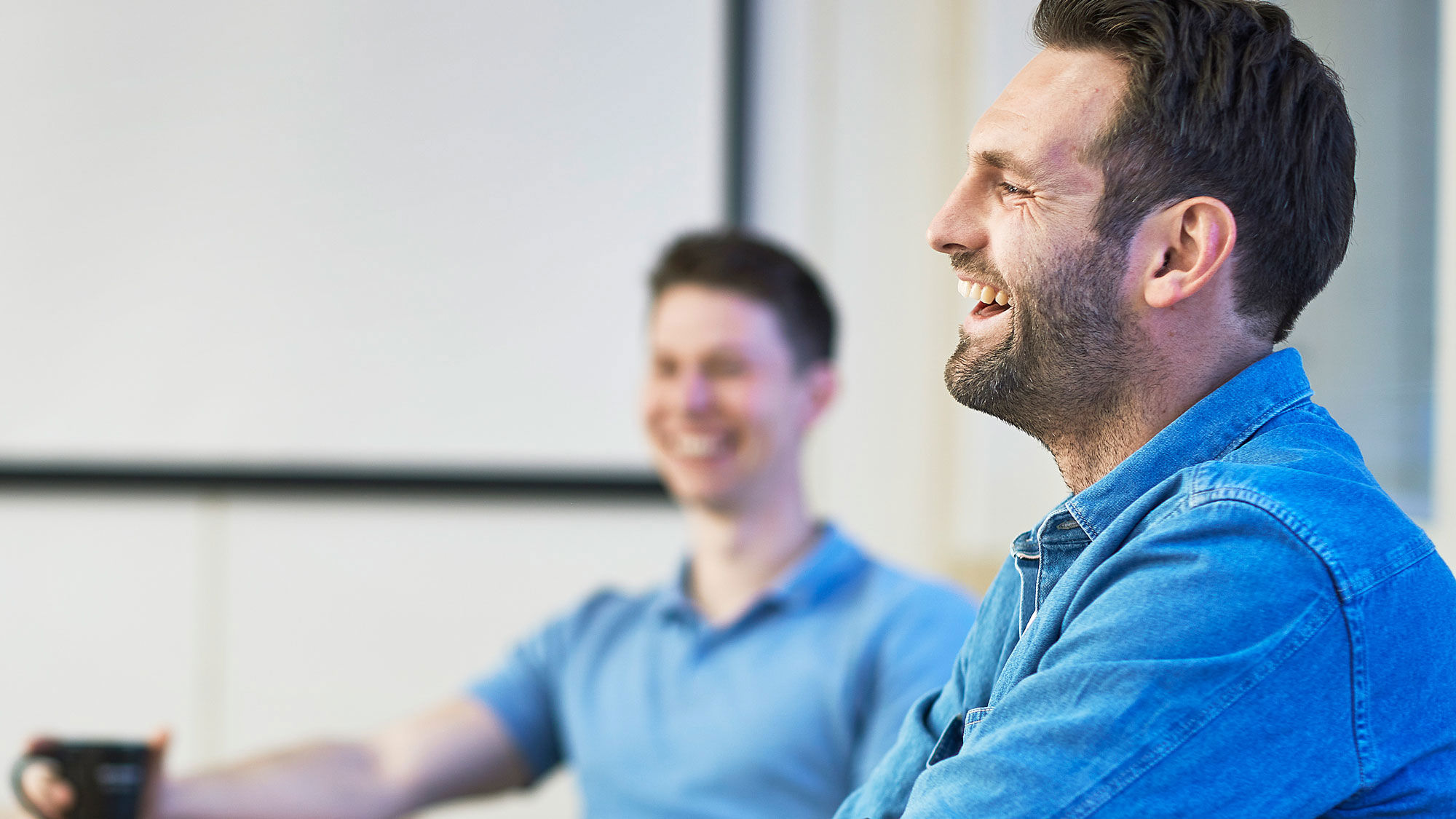 Two male students smiling and laughing. Photo.